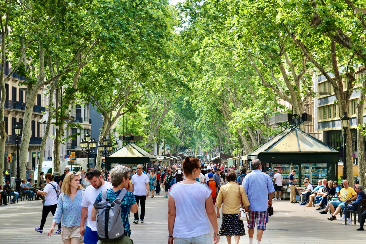 Tourists strolling the tree-lined pedestrian avenue of Las Ramblas, Barcelona